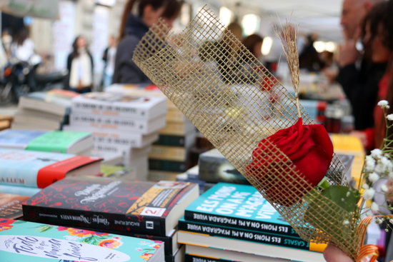 A rose and a book stall during Sant Jordi 2019 in Barcelona (by Mar Vila)